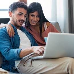 Happy couple looking in laptop | Joseph's Flooring