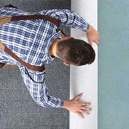 Man rolling carpet for installation | Joseph's Flooring